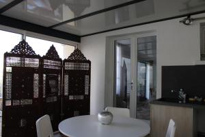 a dining room with a white table and a window at Villa Danemark in Colombes