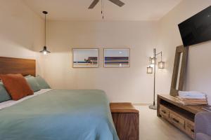 a bedroom with a bed and a flat screen tv at Hotel Hondo in Los Barriles