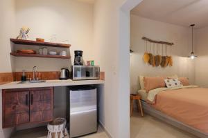 a bedroom with a bed and a kitchen with a microwave at Hotel Hondo in Los Barriles