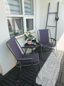 two purple chairs and a table on a porch at Friggjarbrunnur shared home in Reykjavík