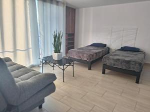 a living room with two beds and a couch at Estudio Lavanda in Santa Rosa de Jáuregui