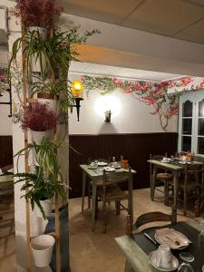 a restaurant with tables and chairs and flowers on the wall at P&R hostals Maria Rosa in Tossa de Mar +20 photos