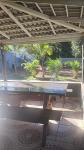 a bench sitting under a pavilion with palm trees at Rancho Carvalho in Alexânia