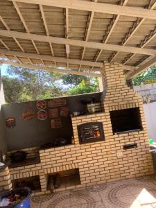 a brick oven in a house with a tv at Rancho Carvalho in Alexânia