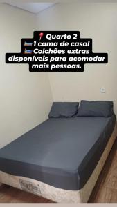 a bed in a room with a sign on the wall at Rancho Carvalho in Alexânia
