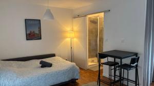 a bedroom with a bed and a table and a lamp at Les Studios de Clément in Poitiers