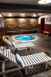 a swimming pool with two benches in a building at The Mammoth Creek Inn in Mammoth Lakes