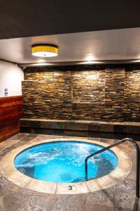 a hot tub in a room with a stone wall at The Mammoth Creek Inn in Mammoth Lakes