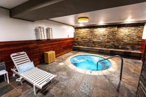 a hot tub with a bench and a chair at The Mammoth Creek Inn in Mammoth Lakes