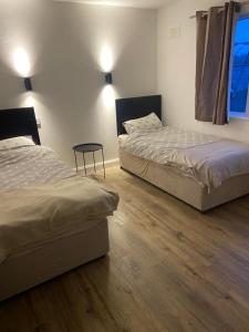 two beds in a room with wooden floors at 12A Benbulben View in Bundoran