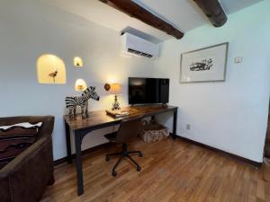 a room with a desk with a computer and a couch at Old Taos Guesthouse B&B in Taos +9 photos