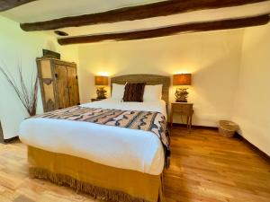 a bedroom with a large bed and a wooden floor at Old Taos Guesthouse B&B in Taos