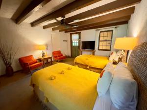 a bedroom with two beds with yellow sheets at Old Taos Guesthouse B&B in Taos