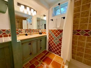 a bathroom with a sink and a mirror at Old Taos Guesthouse B&B in Taos