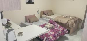 a small room with two beds and a table at elia patra apartment 2 in Patra