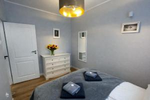a bedroom with a bed and a dresser and a mirror at Ośrodek TVP Sarnówek in Szałkowo +3 photos