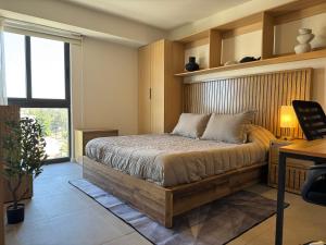 a bedroom with a bed and a desk and a window at Luxury apartment near Andares in Guadalajara +26 photos