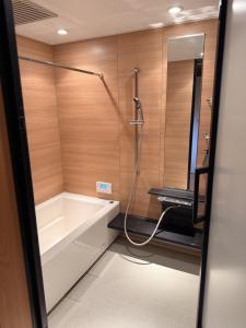 a bathroom with a shower with a tub and a sink at the Mikuni Residence in Sakai +22 photos