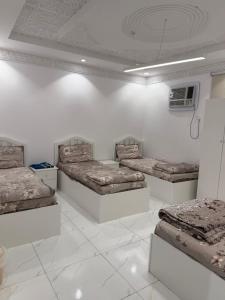 a white room with three beds and a fan at شقق النبلاء in Medina +4 photos