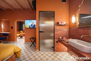 a bathroom with a tub and a sink and a television at Santa Clara - the revolution of living in Chalkida +29 photos