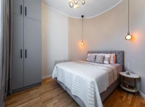 a bedroom with a bed and a large white cabinet at Premium Design, Renovated 2024 Free parking in Riga