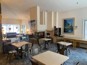 a hotel room with tables and chairs and a living room at Aspen Lodge in Croftville