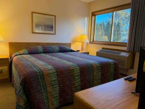 a hotel room with a bed and a window at Aspen Lodge in Croftville +7 photos
