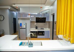 a kitchen with yellow curtains and a kitchen with a sink at Phokera Homes in Lilongwe