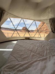 ein Bett in einem Zelt mit Blick auf die Wüste in der Unterkunft Red Twilight Camp in Disah