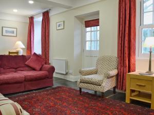 a living room with a red couch and a chair at Fellmere in Ambleside