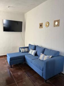 a blue couch in a living room with a tv at Modern 2-Bedroom House in Guaymas in Guaymas
