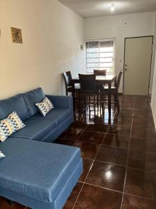 a living room with a blue couch and a table at Modern 2-Bedroom House in Guaymas in Guaymas