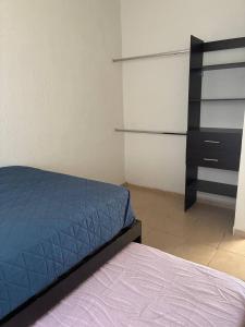 a bedroom with a bed and a dresser and shelves at Modern 2-Bedroom House in Guaymas in Guaymas
