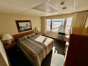 a hotel room with a bed and a window at The Shoreline Inn in Grand Marais