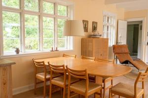 a dining room with a wooden table and chairs at Red Stone House By Dueodde Beach in Neksø +22 photos