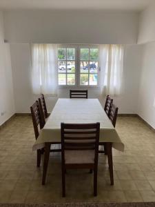a dining room with a white table and chairs at House beach in Puerto Madryn