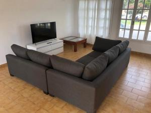 a living room with a large couch and a television at House beach in Puerto Madryn