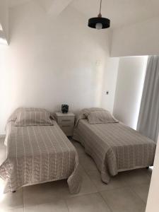 two beds sitting next to each other in a bedroom at House beach in Puerto Madryn