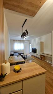 a kitchen and living room with a table and a couch at CL Home Lux in Podgorica