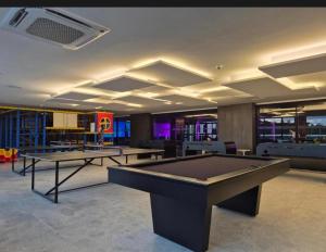 a gaming room with two ping pong tables in it at Porto 2 live in Porto De Galinhas