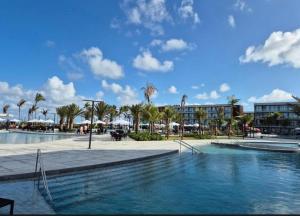 a swimming pool in a resort with palm trees and buildings at Porto 2 live in Porto De Galinhas