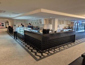 a lobby with a bar with people in a kitchen at Porto 2 live in Porto De Galinhas