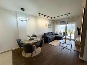 a living room with a couch and a table and chairs at I&I Tesla IV in Kragujevac