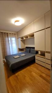 a bedroom with a large bed and white cabinets at CL Home Lux in Podgorica