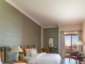 a hotel room with a bed and a balcony at Grand Mercure Petra in Wadi Musa +136 photos