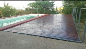 an empty swimming pool with a wooden deck at San Isidro Cabaña in Mendoza +14 photos