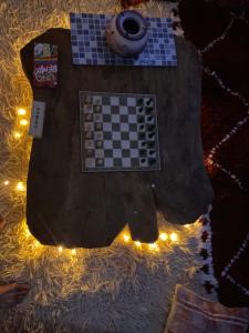 a chess board on a table with lights at sharing is caring in Tamraght Ouzdar +14 photos