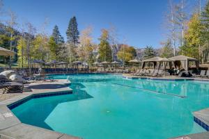 a large swimming pool with chairs and umbrellas at Olympic Valley Summer Sanctuary in Everline Resort in Olympic Valley