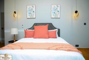 a bedroom with a large bed with orange pillows at Phokera Homes in Lilongwe