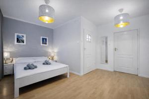a white bedroom with a bed with two teddy bears on it at Ośrodek TVP in Ciechocinek